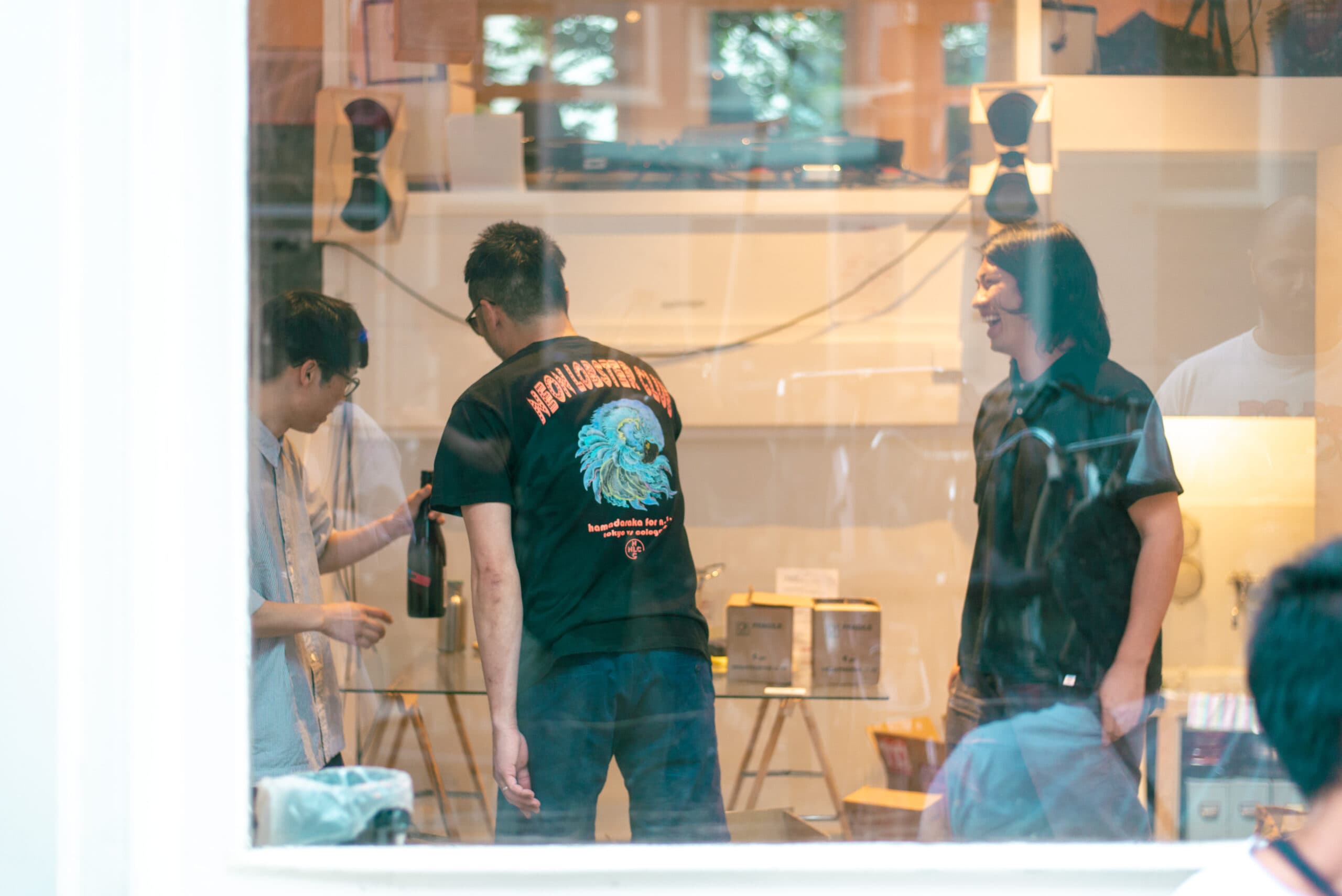 Two KIKUNO speakers flanking a studio window during a Radio KIKUNO x Ongaku Kissa session, guests reflected in the glass