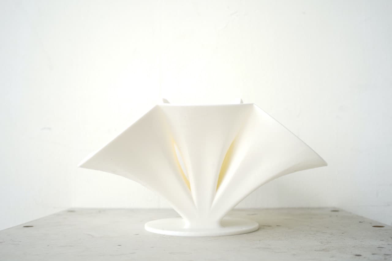 A KIKUNO R-Horn waveguide, sculptural white plaster form, photographed on a plain studio background