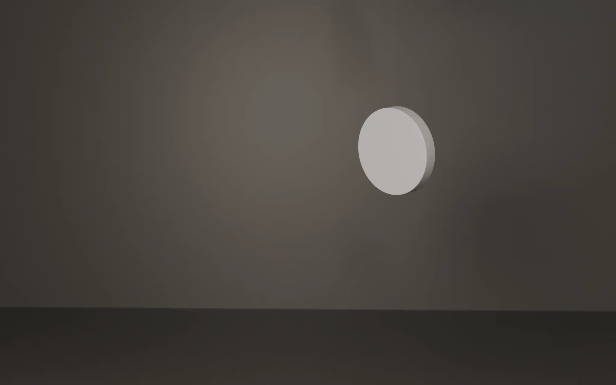 The i speaker's round white diaphragm unit seen edge-on, a thin white blade floating in a dark studio